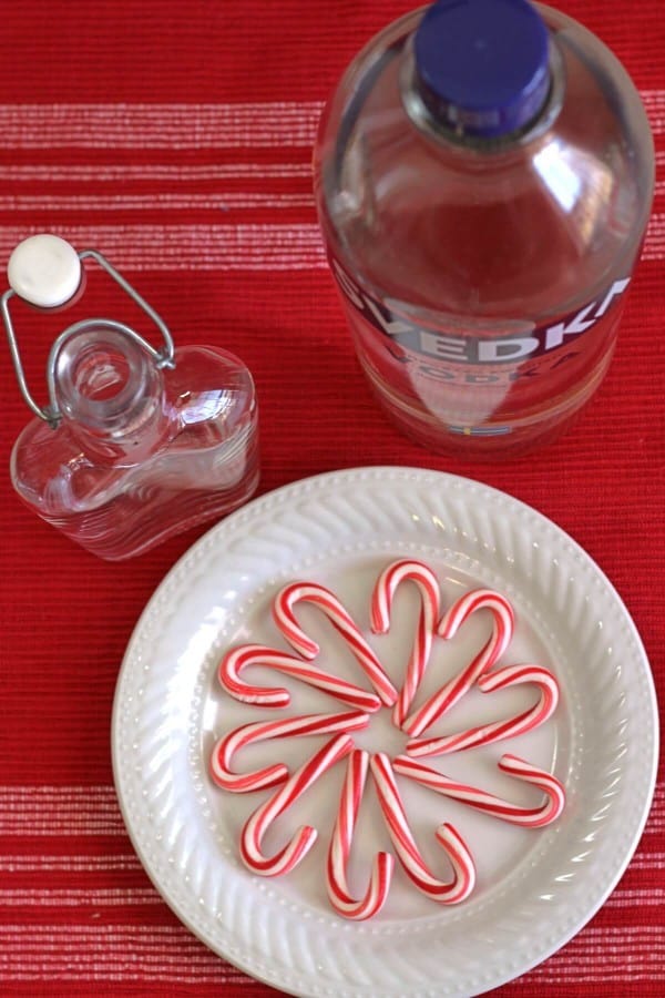 Overhead view of bottle of vodka, flask, and plate with candy canes