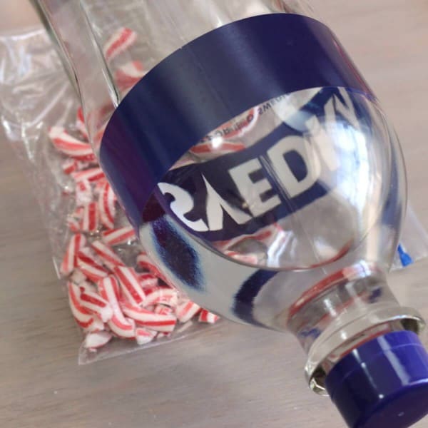 Heavy bottle of vodka rolling over Ziploc bag of candy canes