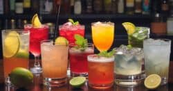 Various colorful cocktails sitting on a bar