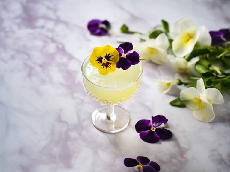 Cocktail with edible pansy garnish