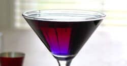 Deep purple colored creme de violette cocktail in martini glass