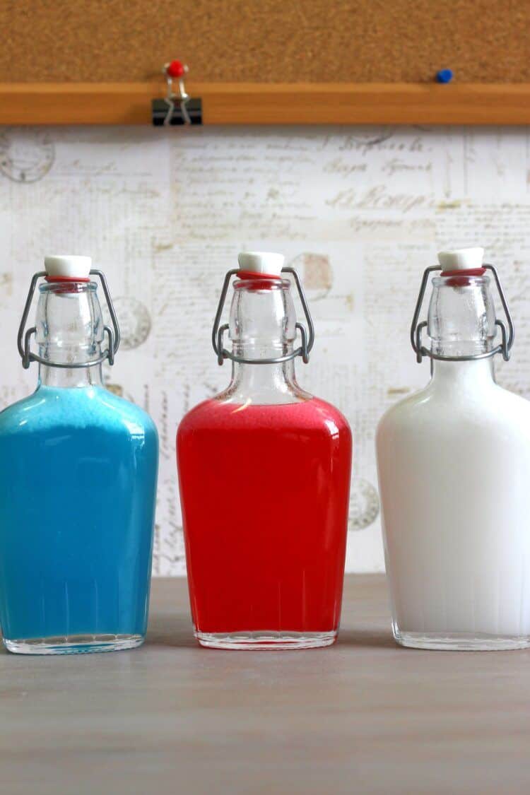 Red, white and blue Independence Day Skittles Vodka in a different flask for each color