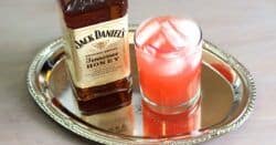 Jack Honey & Grapefruit on silver serving tray next to bottle of Jack Daniel's Honey