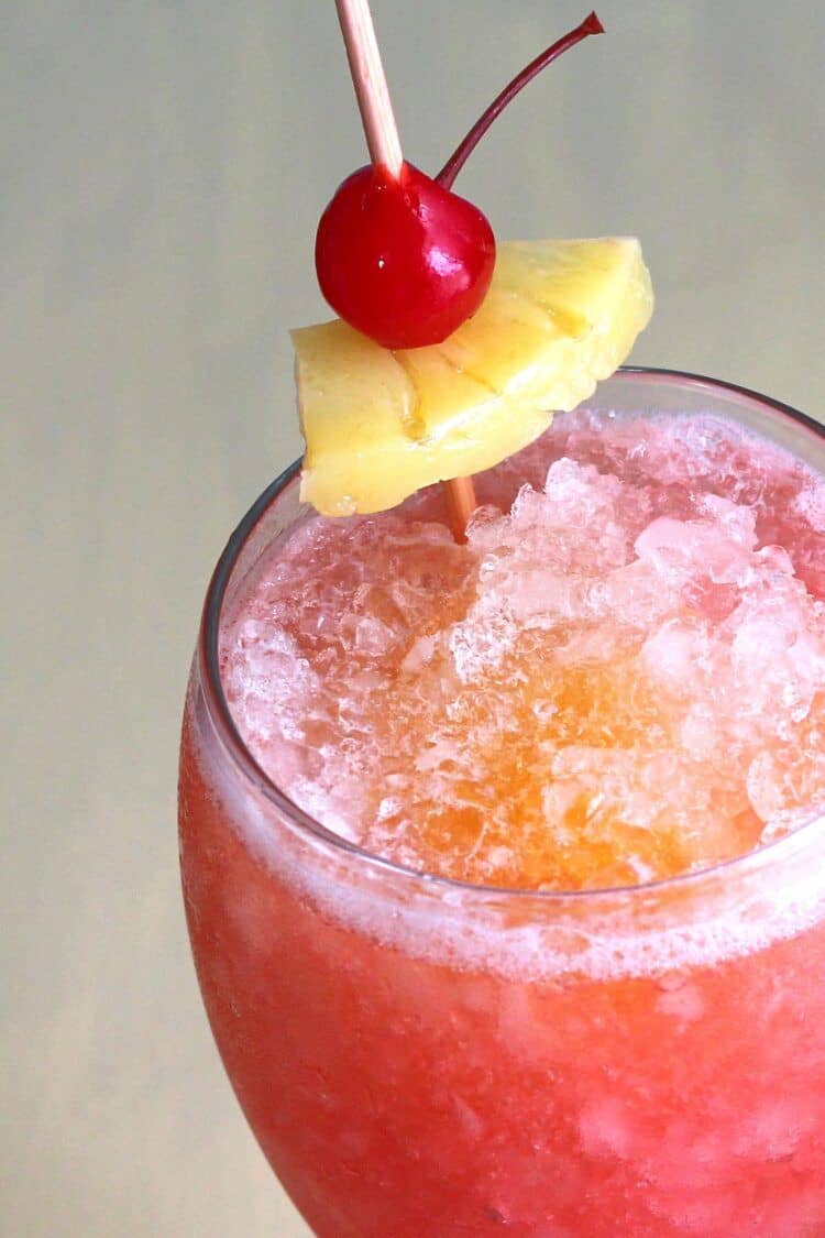 Closeup of Kiss on the Lips drink with pineapple and cherry garnish
