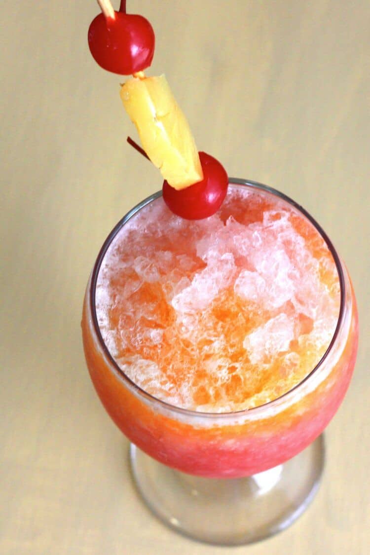 Overhead view of Kiss on the Lips drink with pineapple and cherry garnish