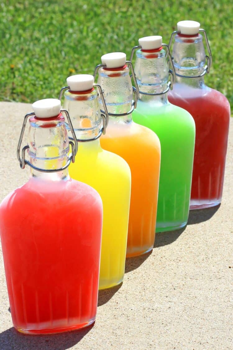 Chilled Skittles Vodka in flasks staggered one in front of another