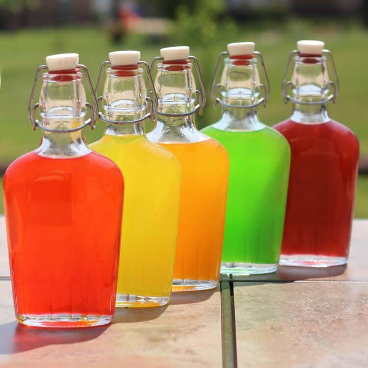 Skittles Vodka in flasks on patio table before chilling