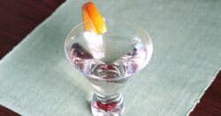 Overhead view of Soho Martini with orange slice on green tablecloth