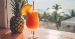 Sweet Tropics Cocktail on window sill in front of beach background